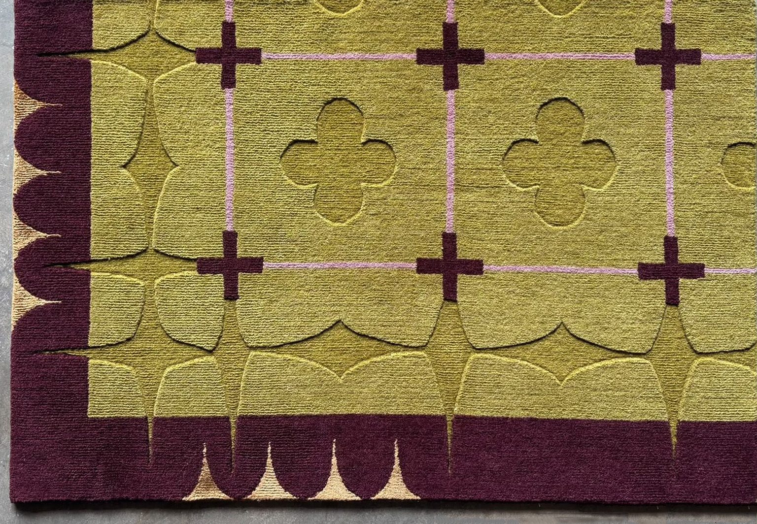 A hand-made Molly Rugburn rug in olive, plum and gold, photographed from above